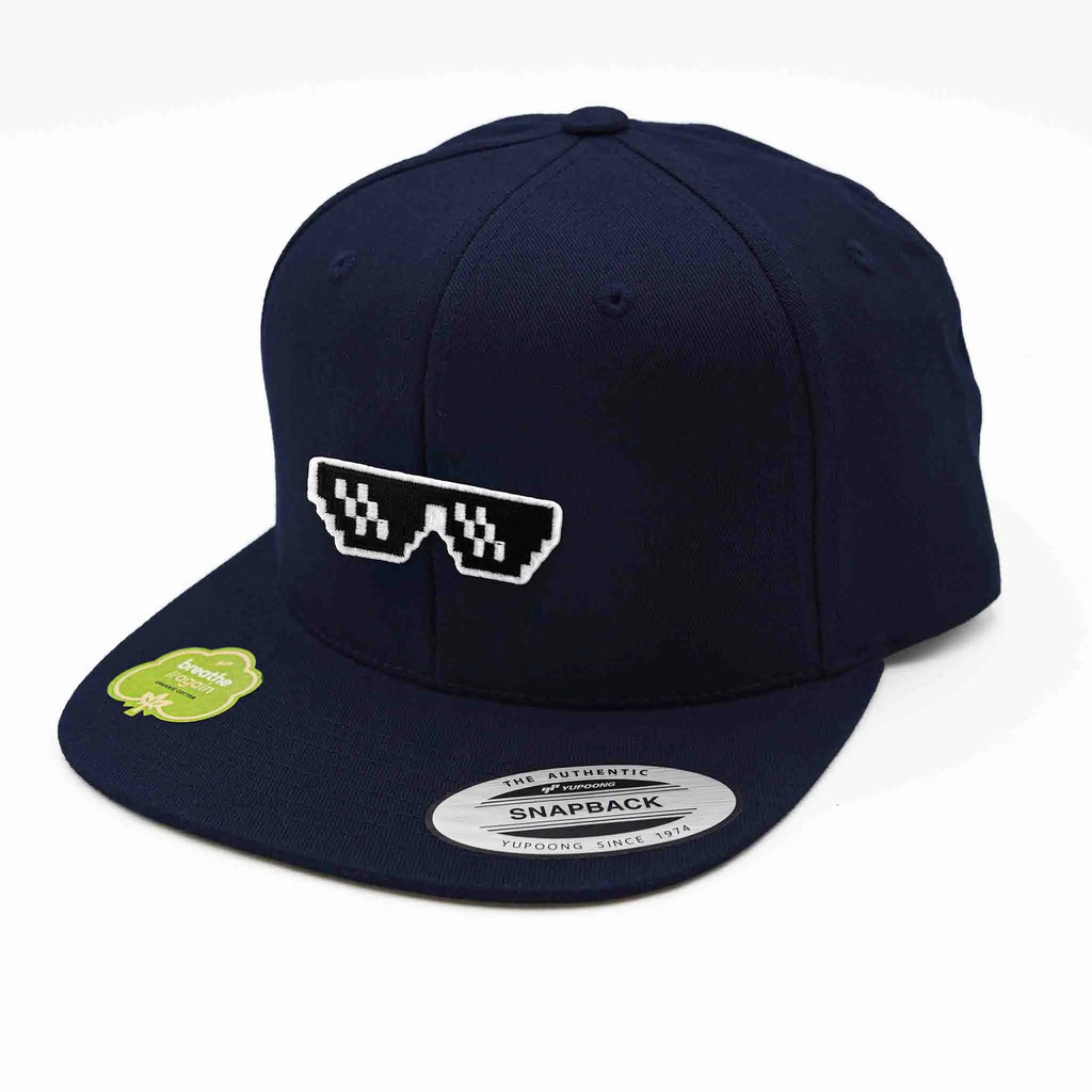 Casquette Flexfit bleue marine snapback avec écusson brodé en forme de lunettes pixel style “thug life”, modèle streetwear personnalisable avec velcro et écussons interchangeables.