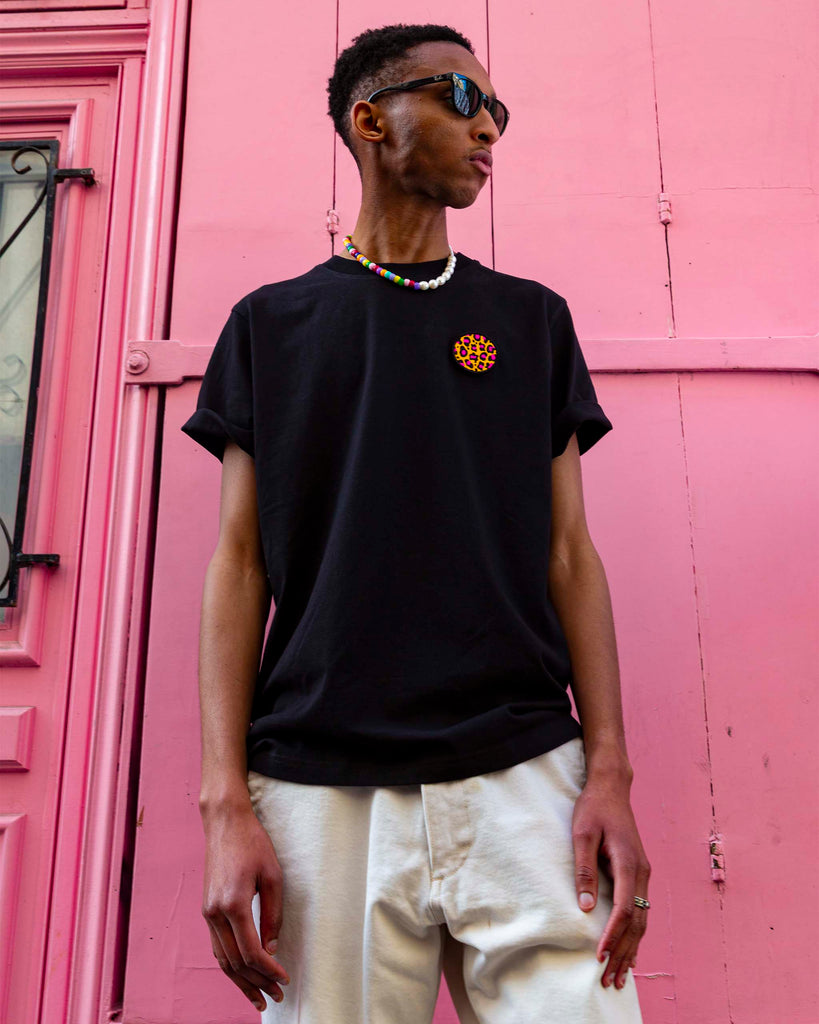 T-shirt noir avec motif léopard rose en écusson circulaire – design graphique et épuré