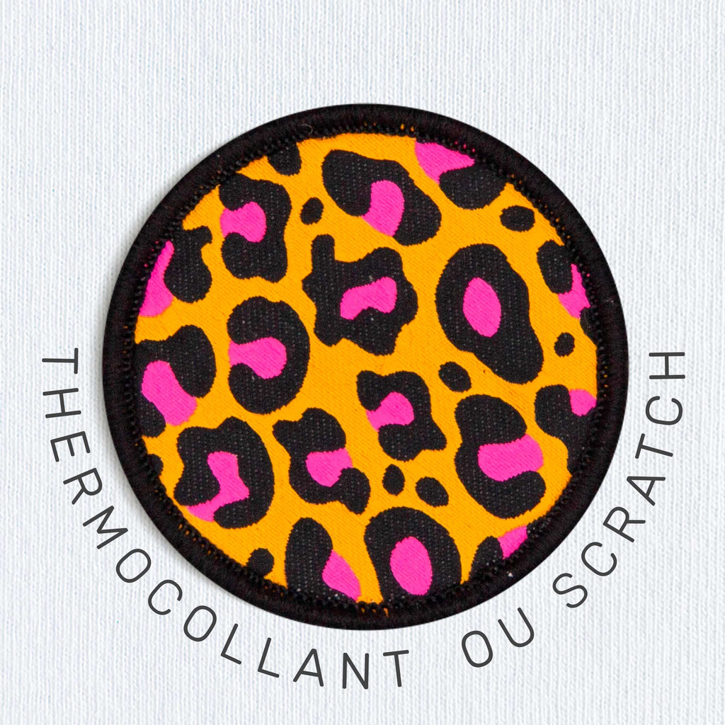 Modèle homme portant un t-shirt noir avec motif léopard et écusson circulaire sur la poitrine