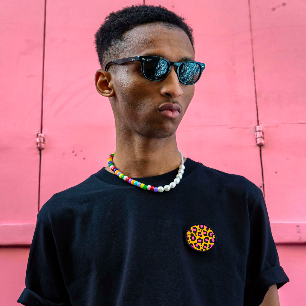 Portrait d’un homme portant un t-shirt noir avec un écusson léopard circulaire – design minimaliste