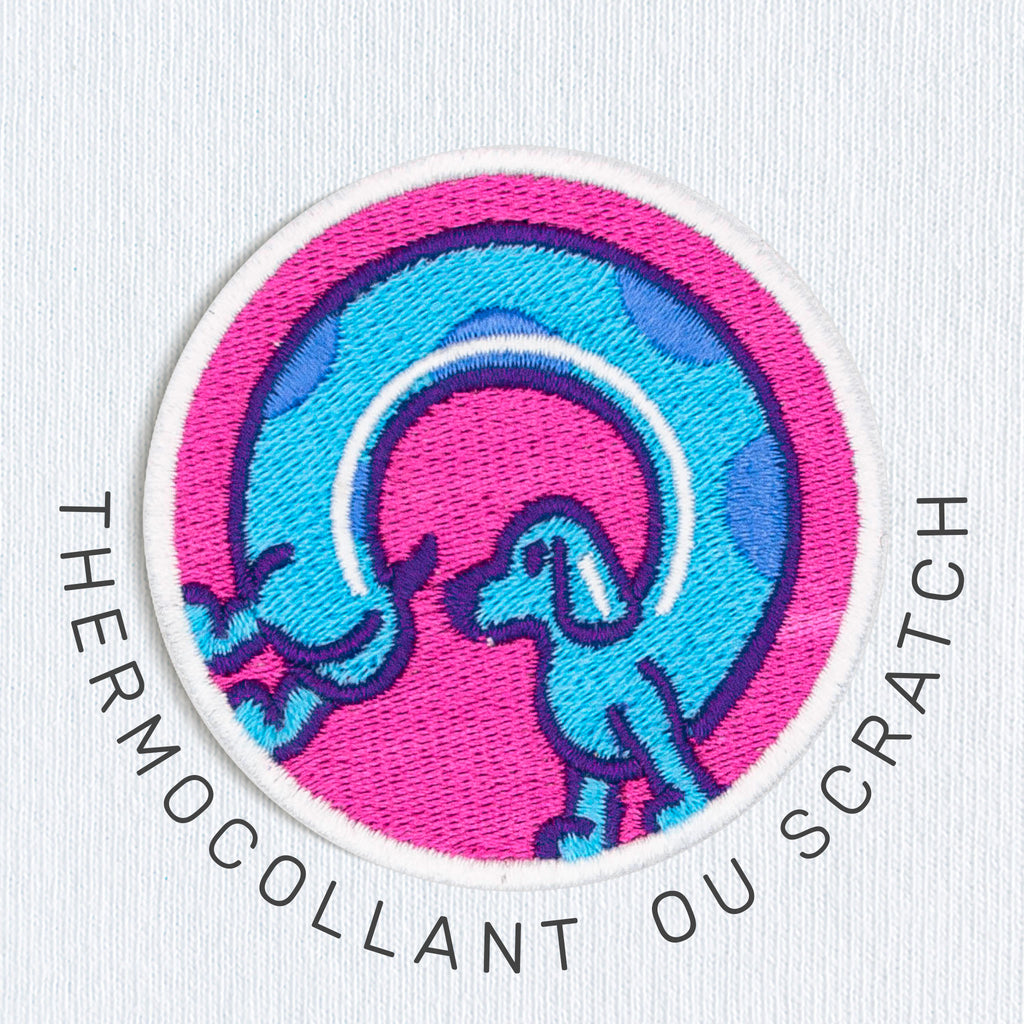  Gros plan sur un écusson coloré représentant un chien saucisse, disponible en version thermocollant ou scratch.