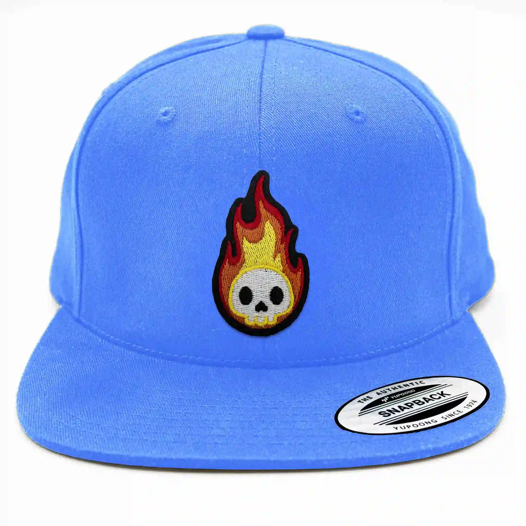 Casquette Flexfit bleu clair avec écusson thermocollant tête de mort enflammée brodée, accessoire audacieux.