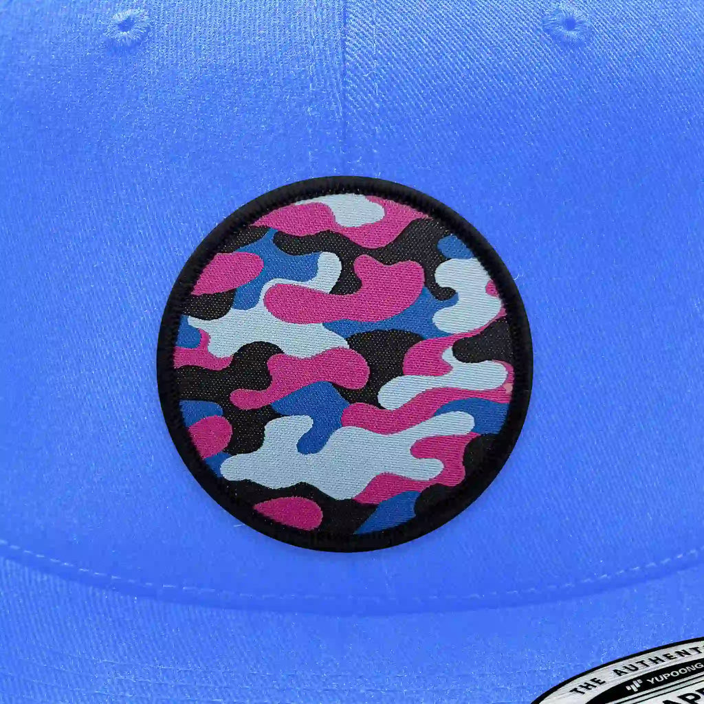 Casquette bleu clair avec écusson thermocollant motif camouflage bleu, rose et noir.