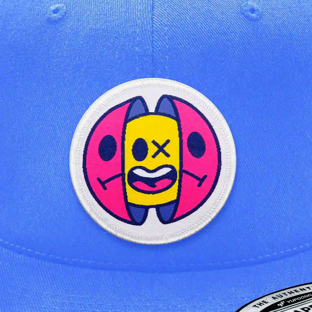 Casquette bleu clair avec écusson thermocollant capsule colorée jaune, rose et bleu.