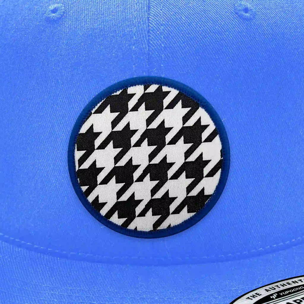 Casquette bleu clair avec écusson thermocollant rond imprimé en motif pied-de-poule noir et blanc, design rétro et chic.