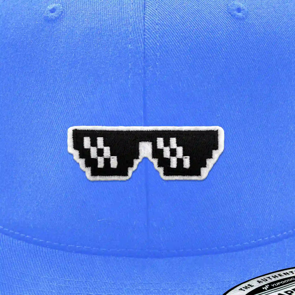 Casquette bleu clair avec écusson thermocollant phosphorescent brodé en forme de lunettes noires pixelisées style Thug Life, look urbain et tendance.