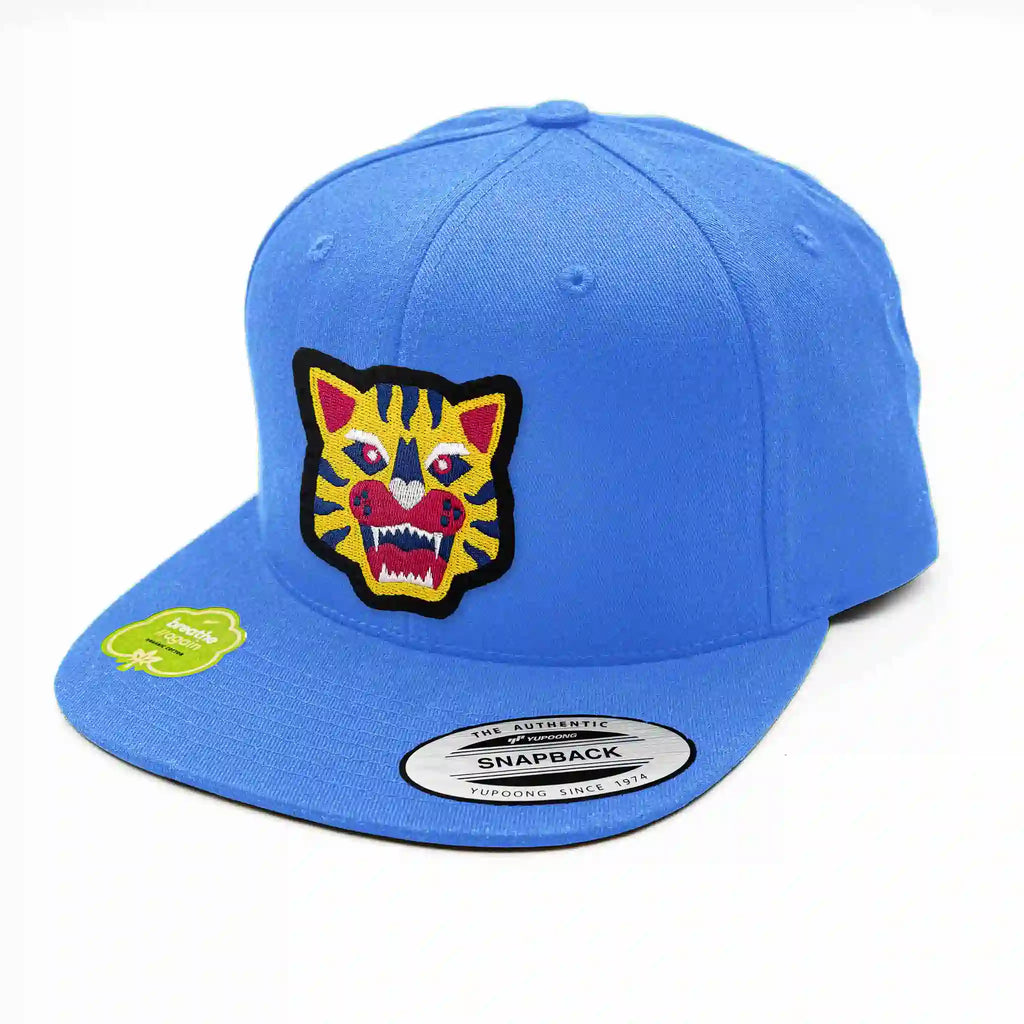 Casquette Flexfit bleu clair avec écusson velcro tête de tigre brodée, snapback stylée pour look urbain.