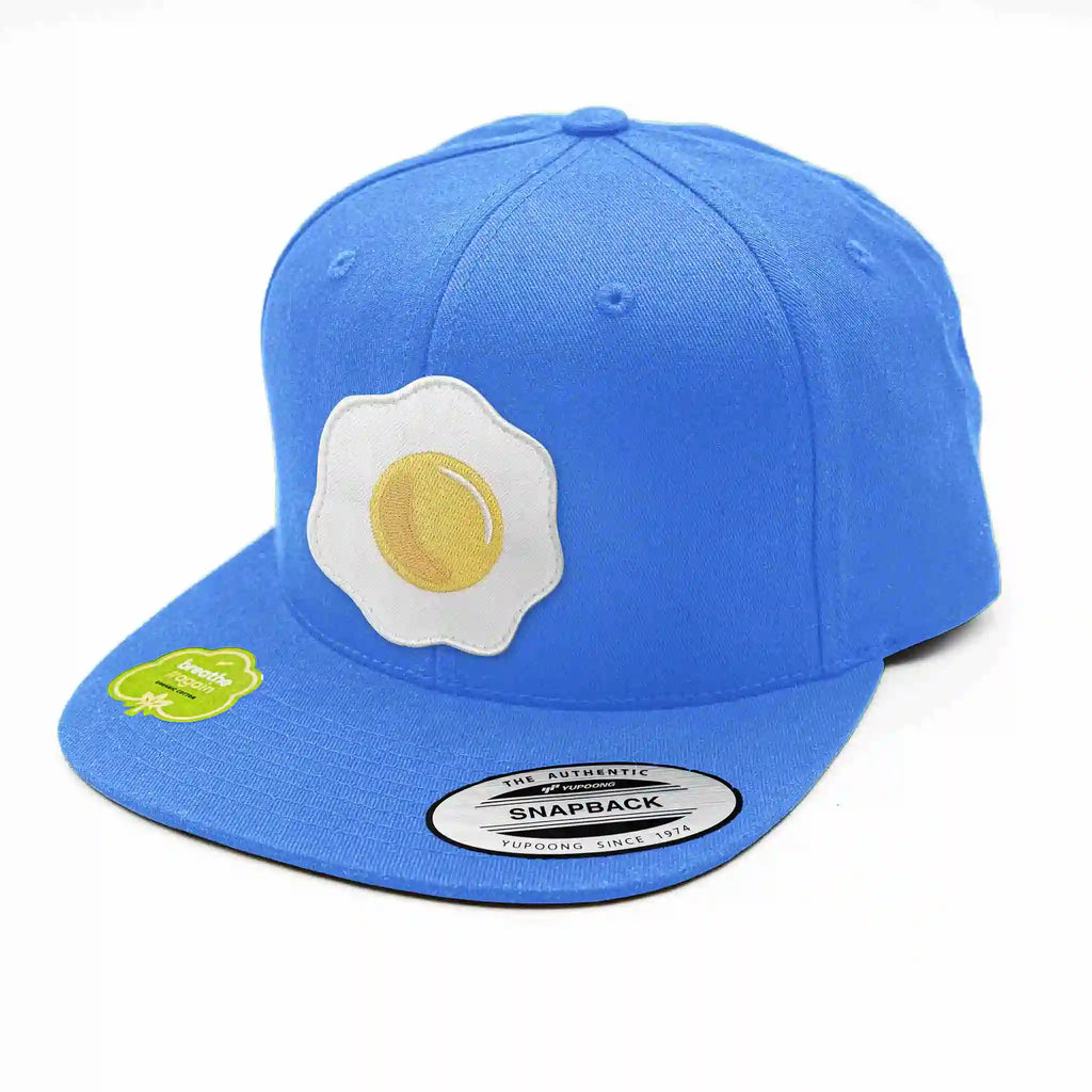 Casquette Flexfit bleu clair avec écusson interchangeable œuf au plat brodé, snapback tendance et originale.