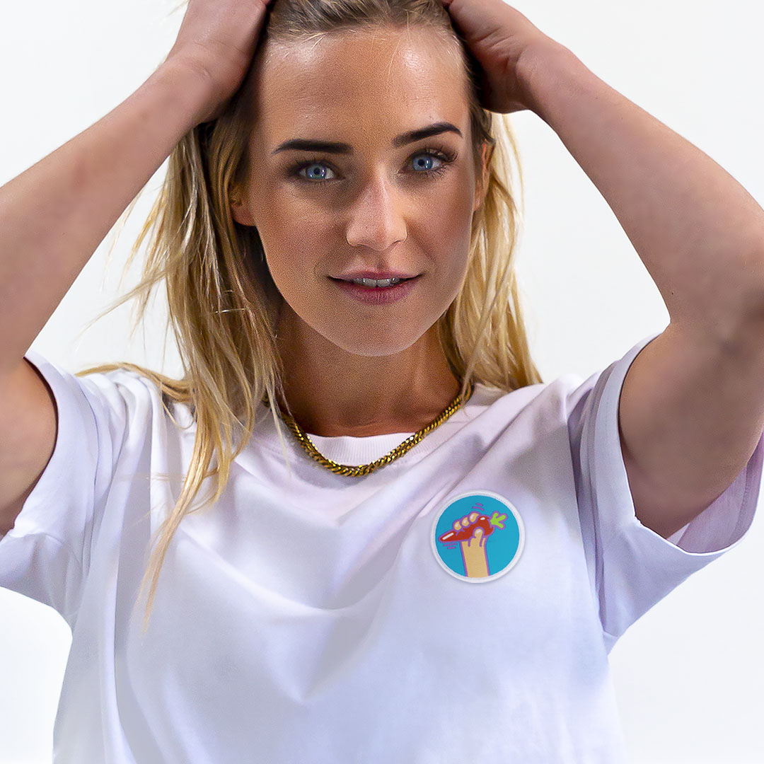 Femme avec les mains dans les cheveux portant un super t-shirt en coton bio avec un écusson carotte