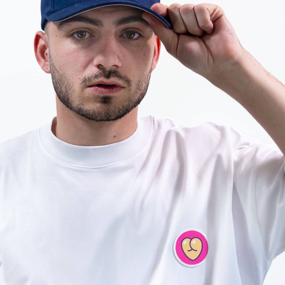 Homme avec une casquette portant un super t-shirt en coton bio avec un écusson coeur