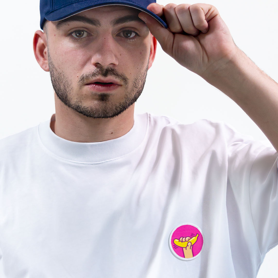 Homme avec une casquette portant un super t-shirt en coton bio avec un écusson banane positionné sur le cœur